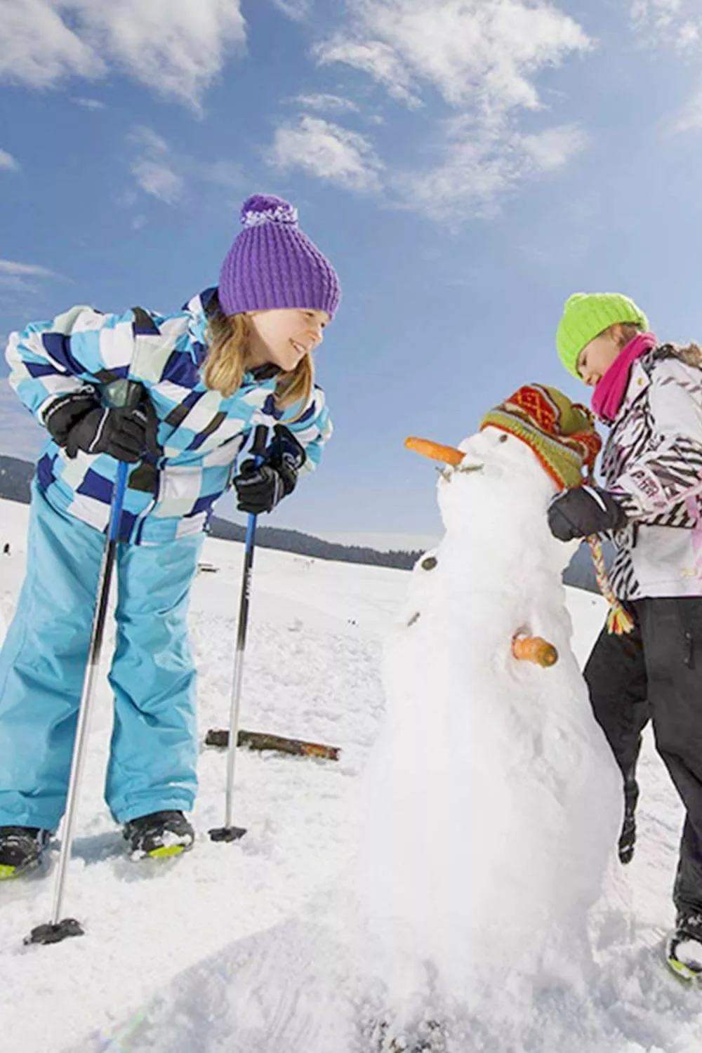 Spaß im Schnee beim Schneemannbauen Familienzeit im Winterurlaub